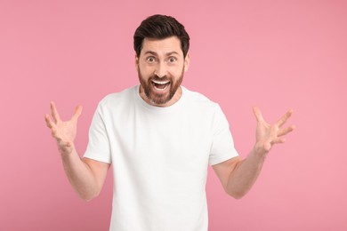 Portrait of surprised man on pink background