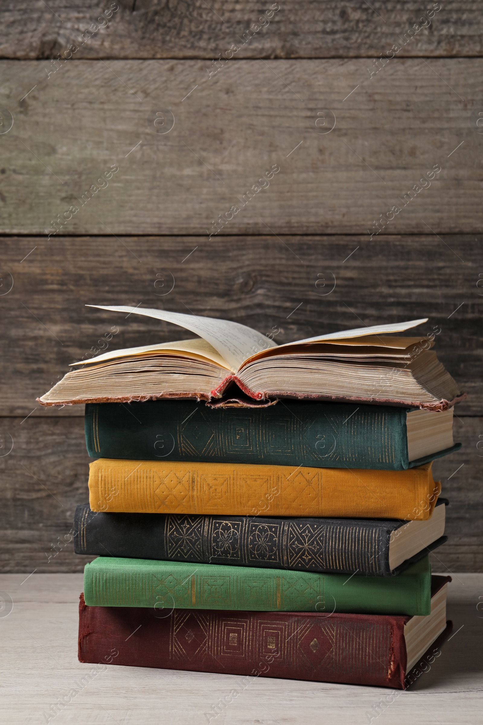 Photo of Stack of old hardcover books on white wooden table