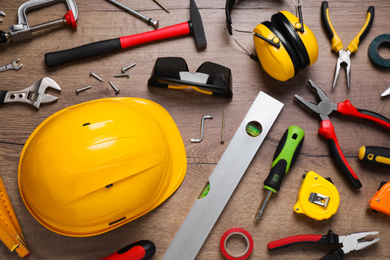 Flat lay composition with different construction tools on wooden background