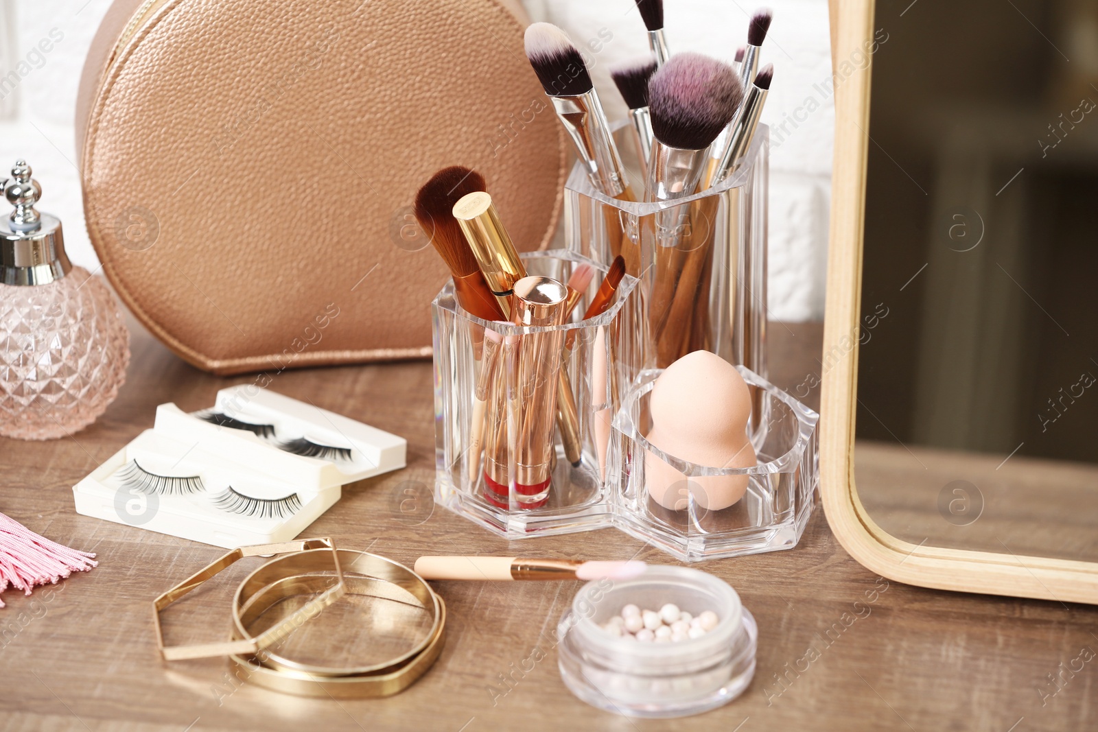 Photo of Different makeup products and accessories on dressing table