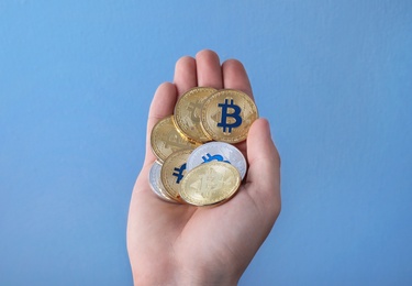 Photo of Man holding bitcoins on color background, closeup