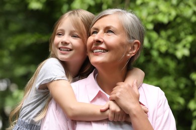 Photo of Happy grandmother with her granddaughter spending time together outdoors
