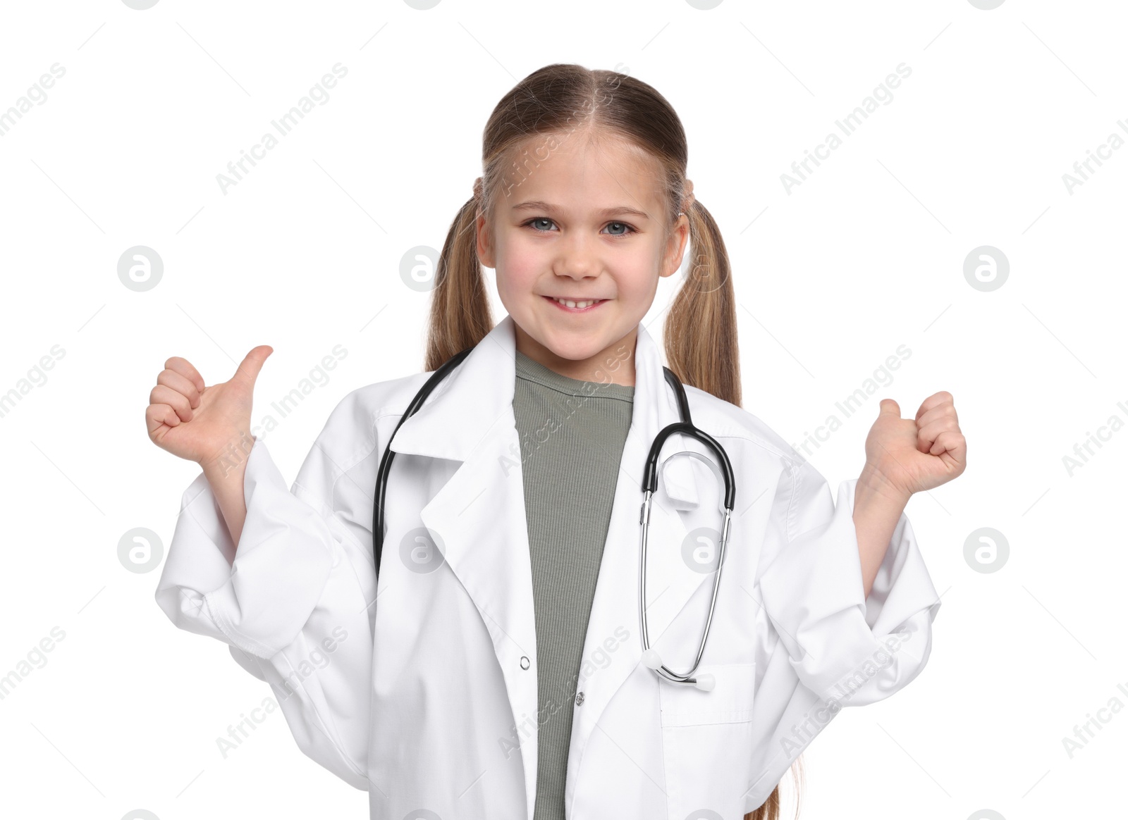 Photo of Little girl in medical uniform with stethoscope showing thumbs up on white background