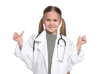 Photo of Little girl in medical uniform with stethoscope showing thumbs up on white background