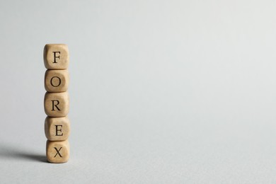 Photo of Word Forex made of wooden cubes with letters on light grey background. Space for text