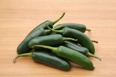 Pile of fresh ripe green jalapeno peppers on wooden table