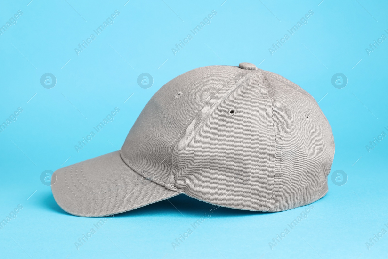 Photo of Stylish grey baseball cap on light blue background