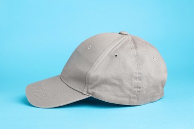 Stylish grey baseball cap on light blue background