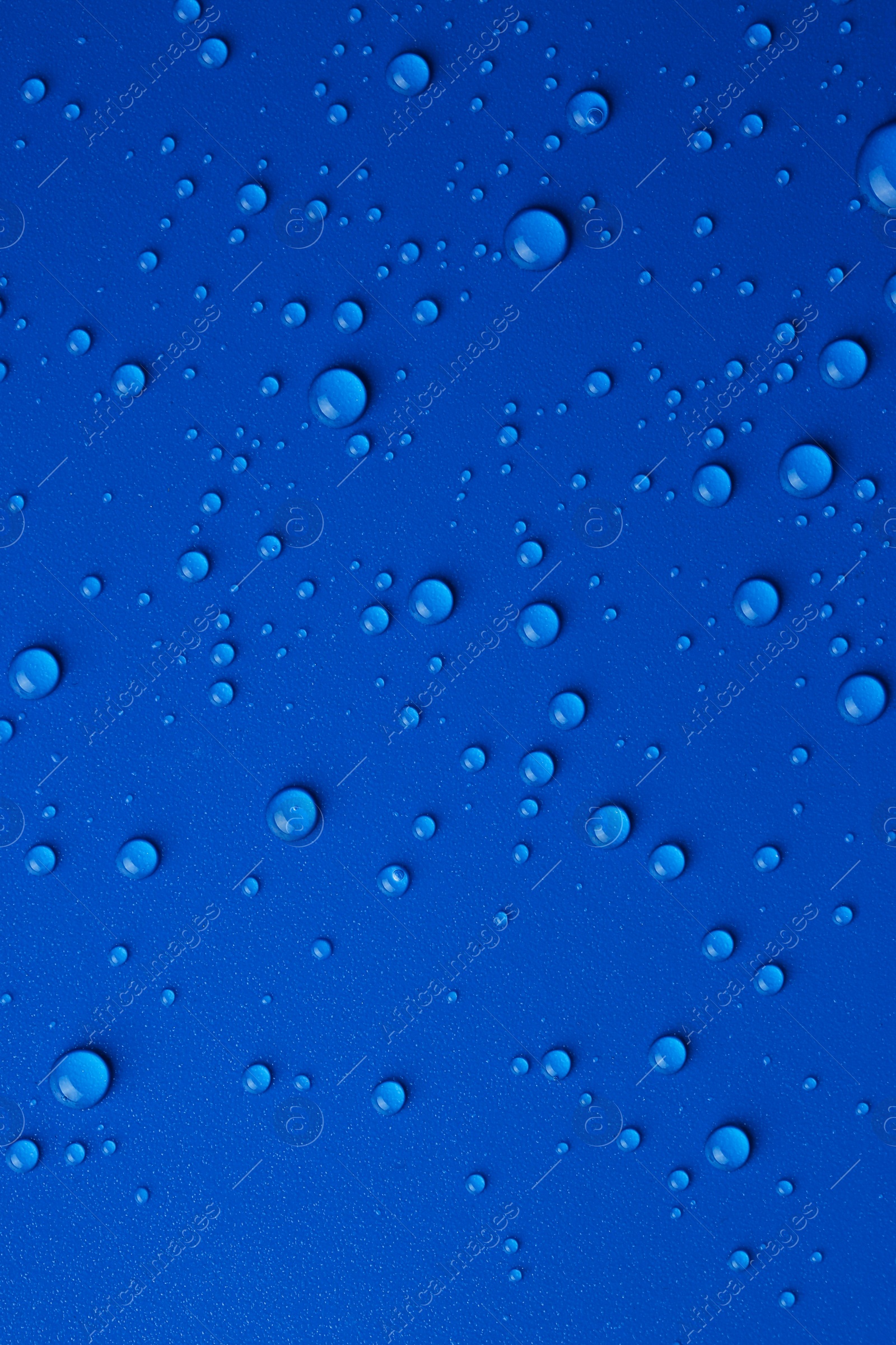 Photo of Water drops on blue background, top view