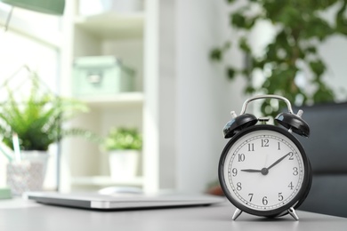 Alarm clock on table in office. Time to work