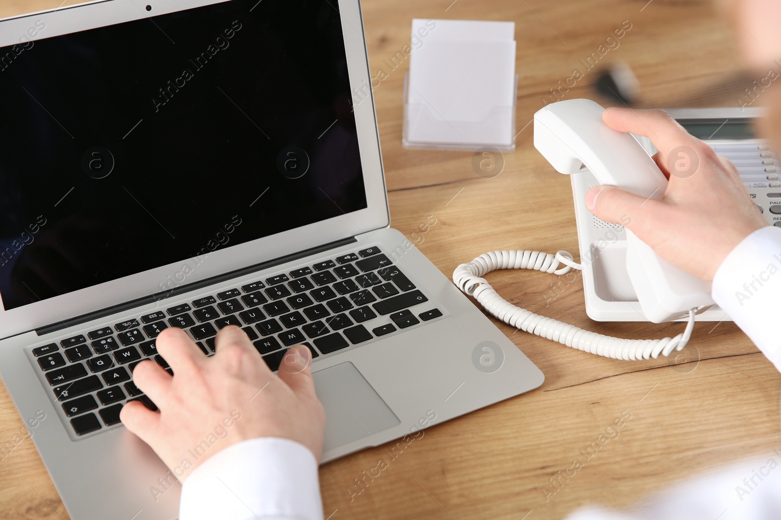 Photo of Male technical support operator working in office, closeup of hands