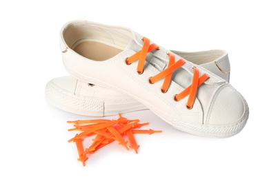 Photo of Sportive shoes with orange silicone laces on white background