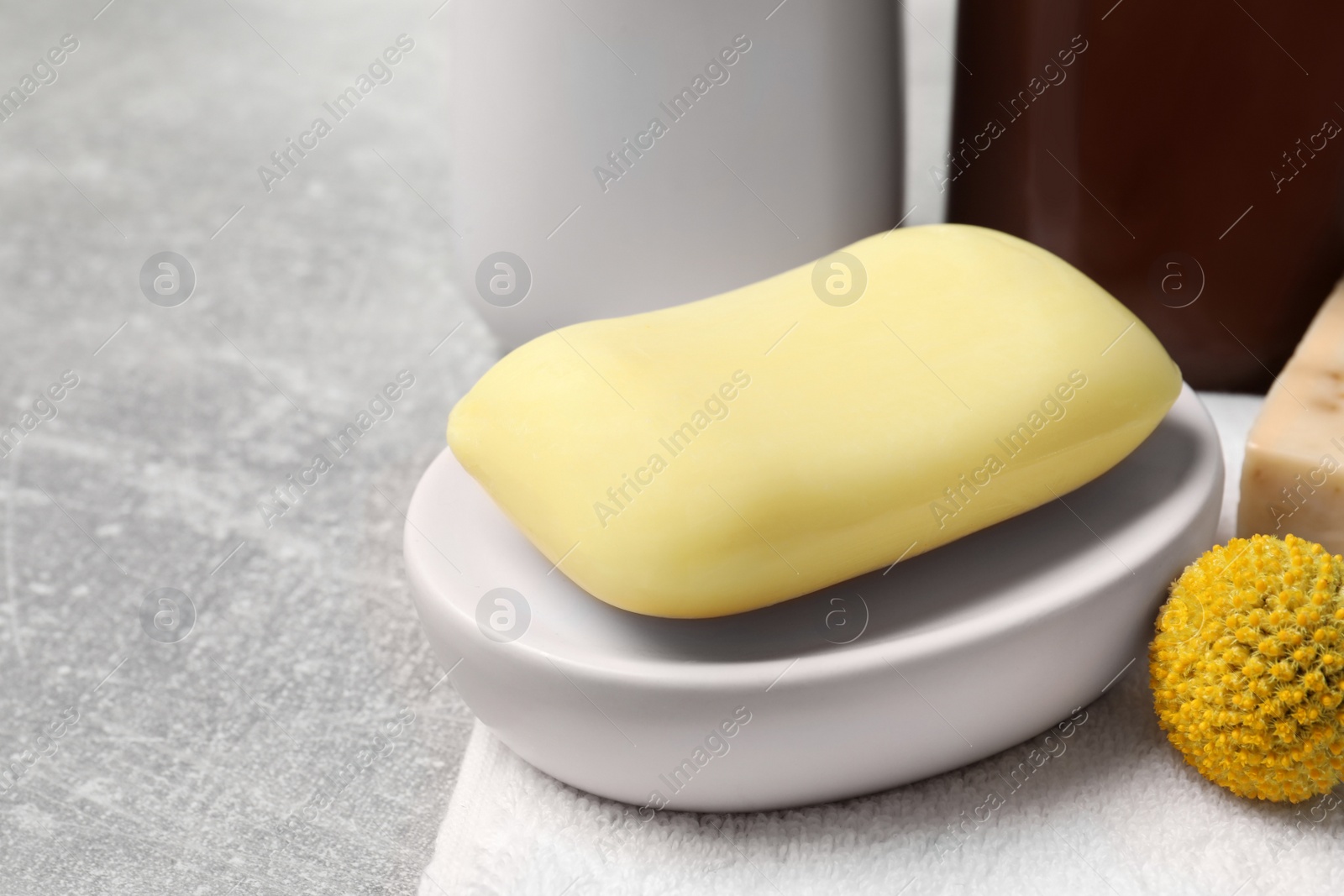 Photo of Dish with soap bar on light grey table, closeup. Space for text