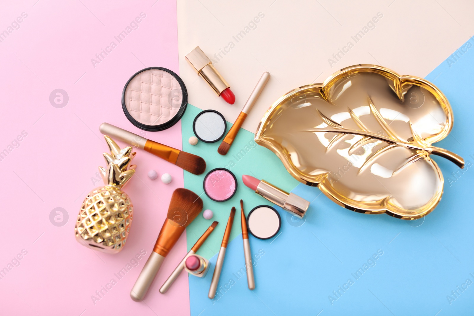 Photo of Makeup products and brushes on color background