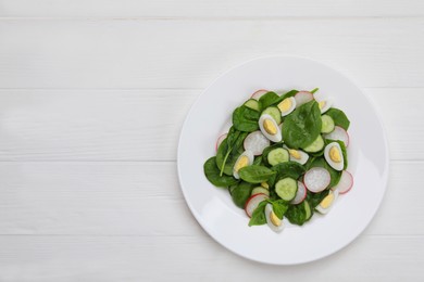 Delicious salad with boiled eggs, radish and spinach on white wooden table, top view. Space for text