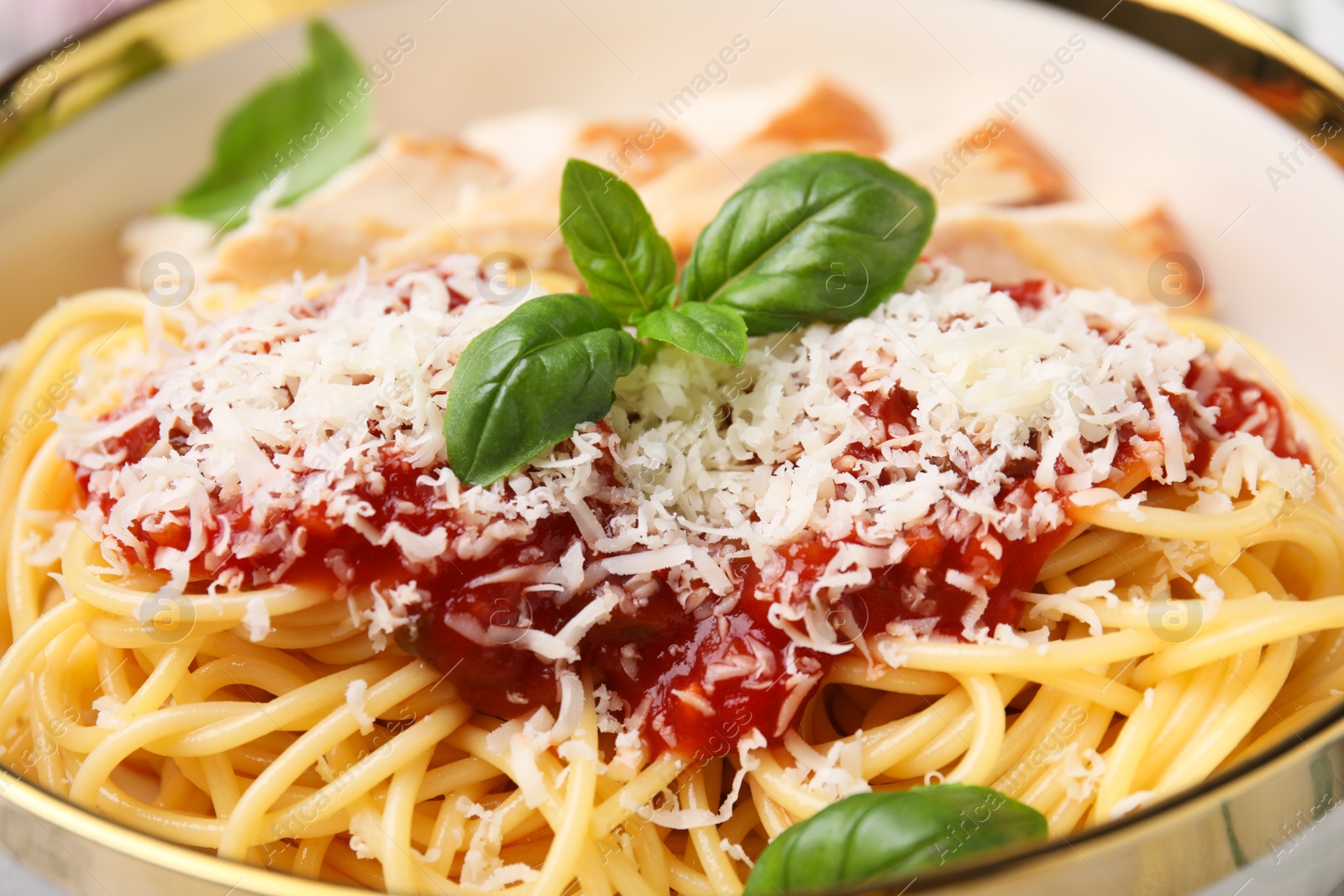 Photo of Delicious pasta with tomato sauce, chicken and parmesan cheese in bowl, closeup