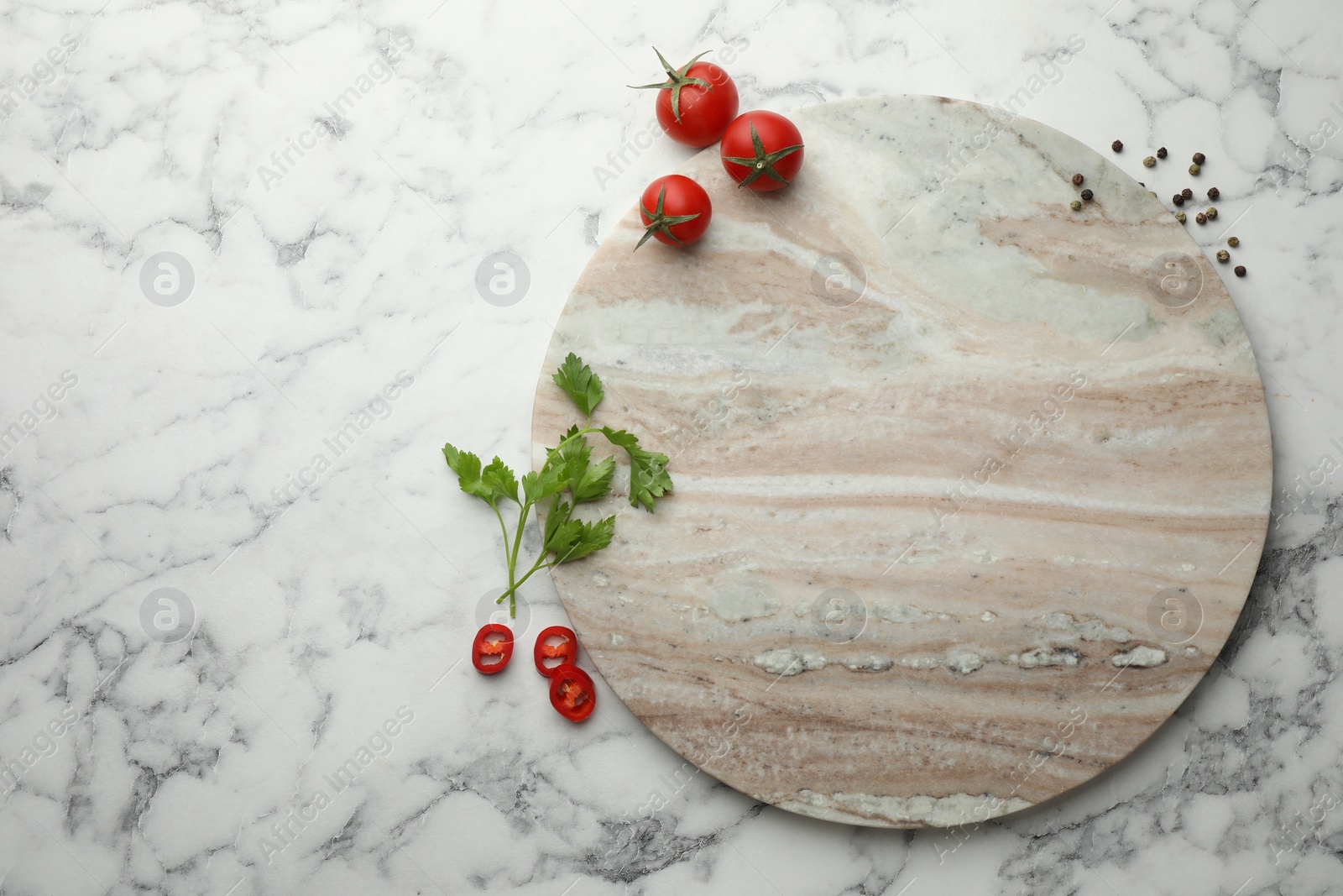 Photo of Cutting board, parsley, pepper and tomatoes on white marble table, flat lay. Space for text