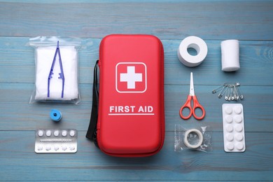 Photo of Flat lay composition with first aid kit on blue wooden table