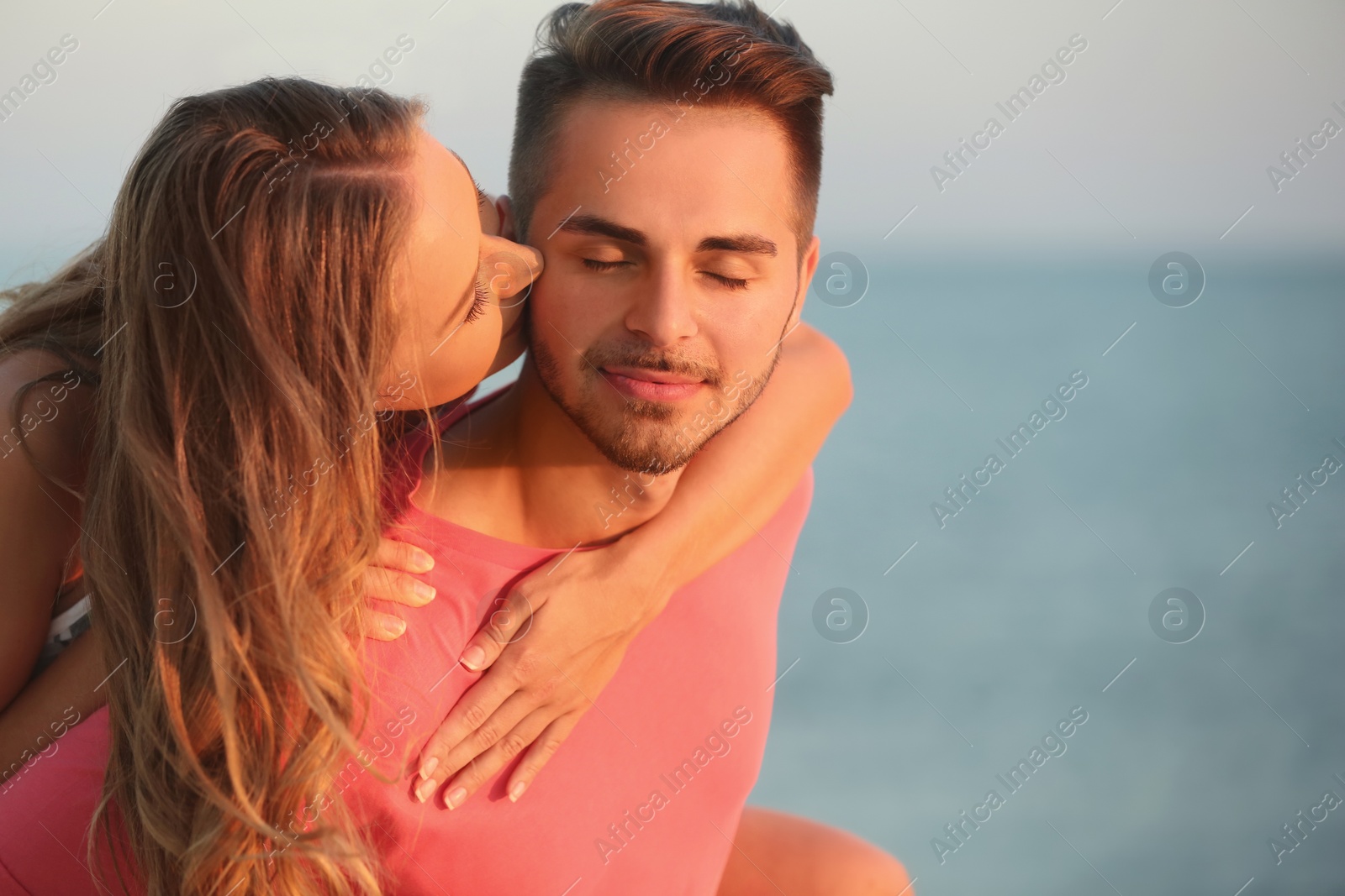 Photo of Happy young couple playing together on beach