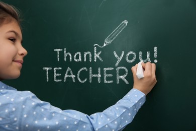 Image of Cute little boy written phrase Thank You Teacher on green chalkboard