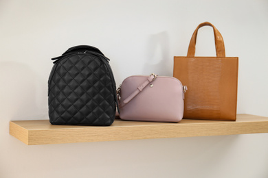 Photo of Stylish woman's bags on shelf in boutique