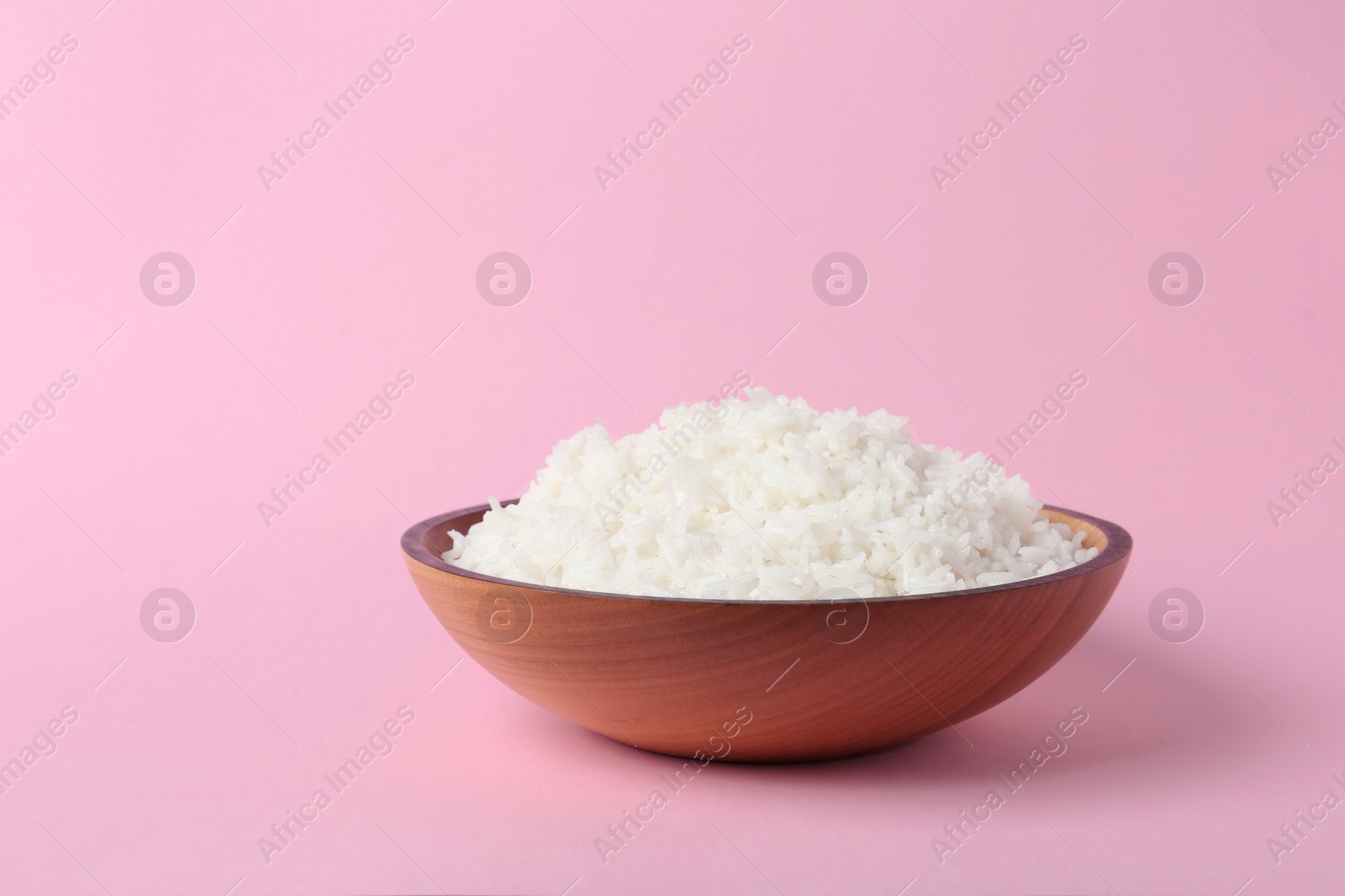 Photo of Bowl of boiled rice on color background