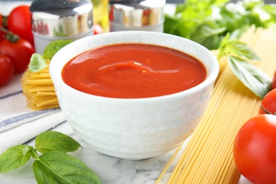 Photo of Bowl of tasty tomato sauce served on table, closeup