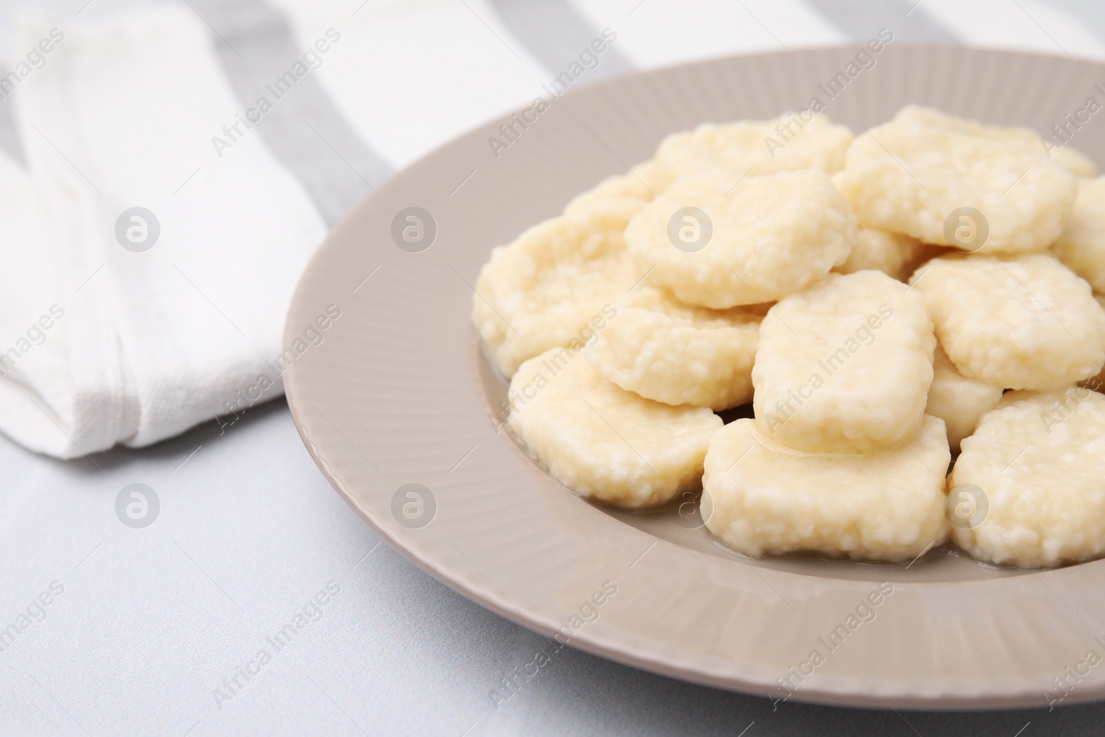 Photo of Plate of tasty lazy dumplings on white table, closeup
