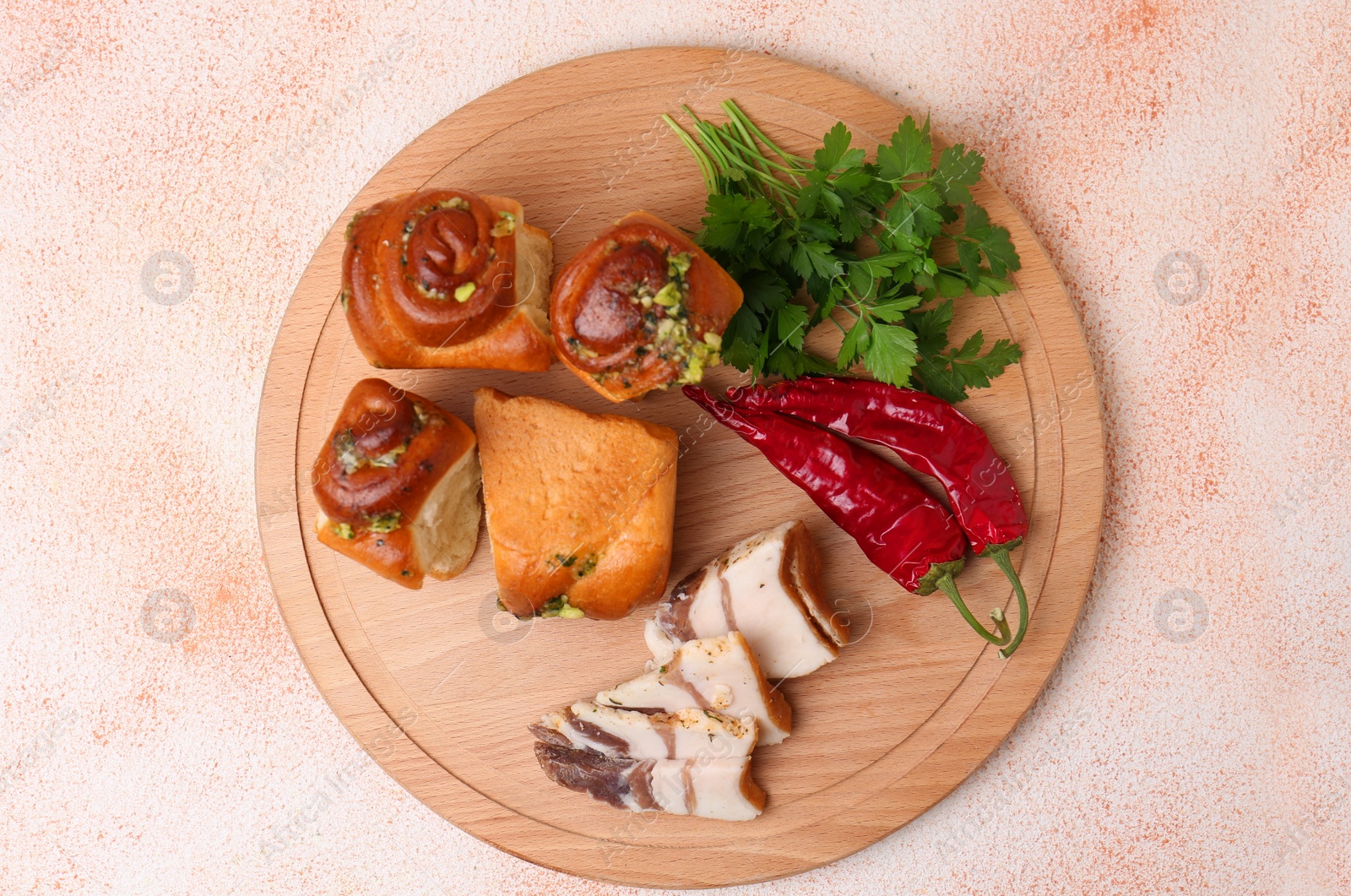 Photo of Delicious pampushky (buns with garlic), salo, peppers and parsley on color textured table, top view