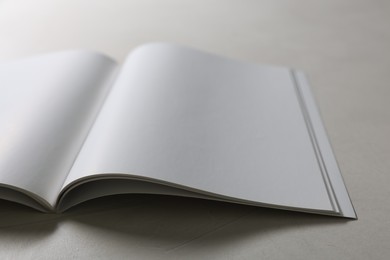 Photo of Open notebook with blank pages on grey textured table, closeup. Mockup for design