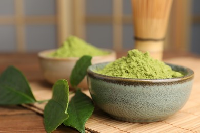 Photo of Bowl of green matcha powder on wooden table, closeup