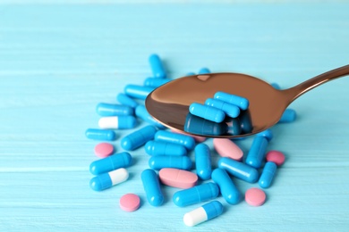 Spoon with weight loss pills over color table