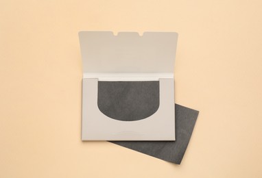 Photo of Facial oil blotting tissues on beige background, flat lay. Mattifying wipes