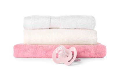 Photo of Stacked towels and baby pacifier isolated on white