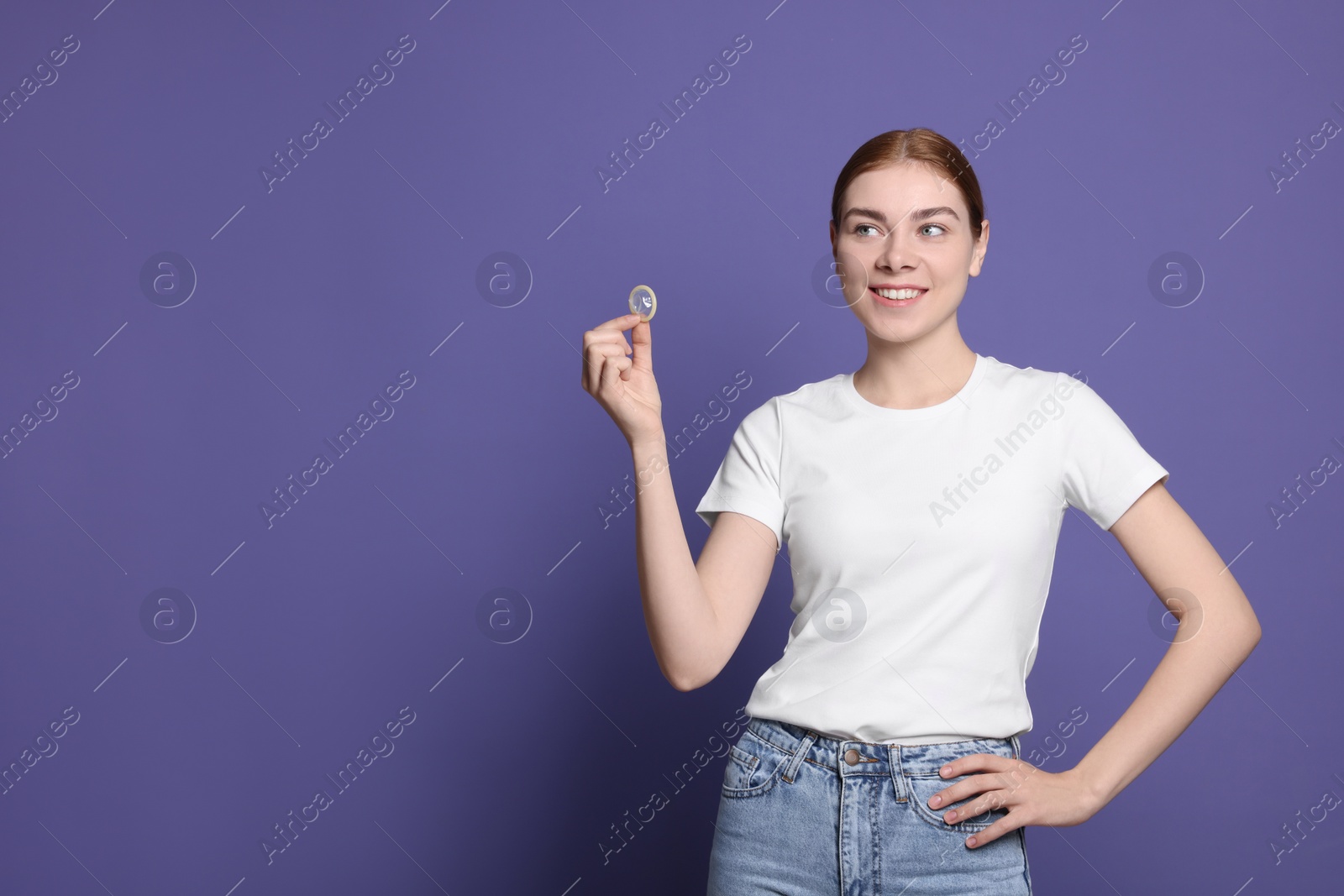 Photo of Woman holding condom on purple background, space for text. Safe sex