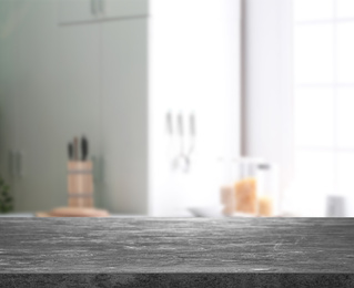 Image of Empty grey stone surface and blurred view of kitchen with modern window 