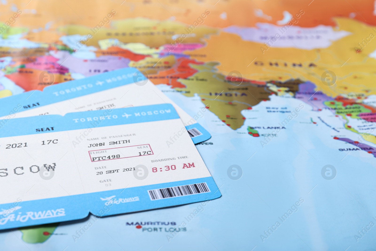 Photo of Avia tickets on world map, closeup. Travel agency concept