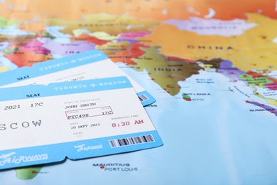 Photo of Avia tickets on world map, closeup. Travel agency concept