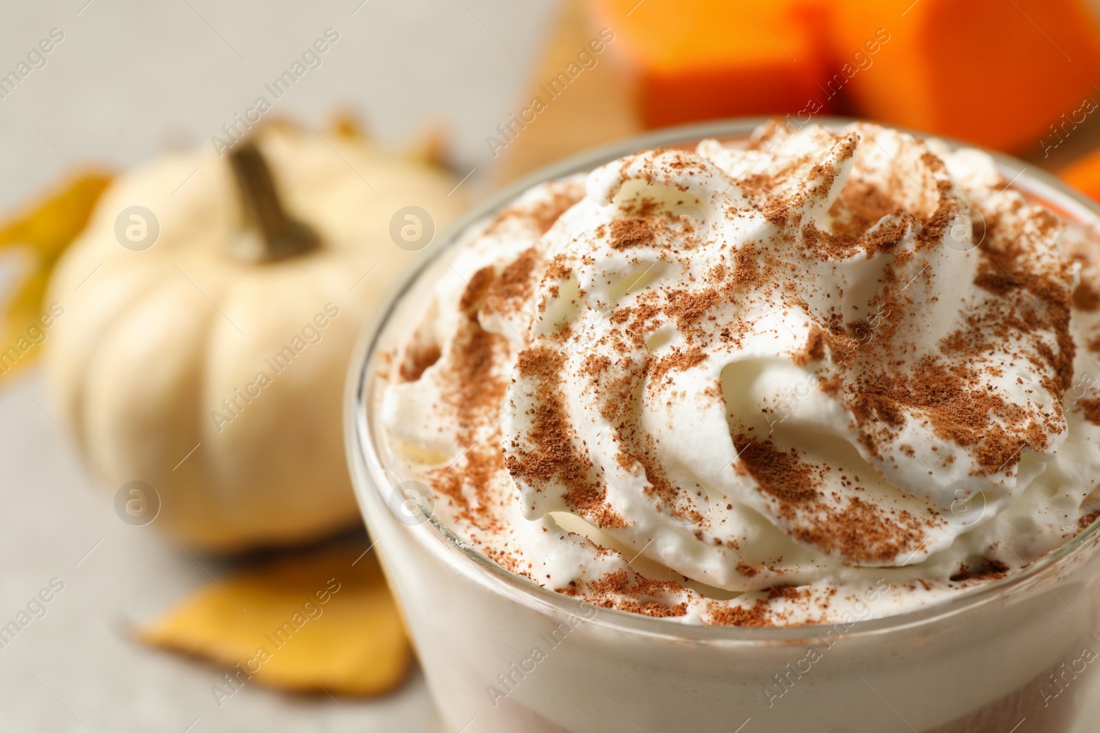 Photo of Delicious pumpkin latte with whipped cream on table, closeup