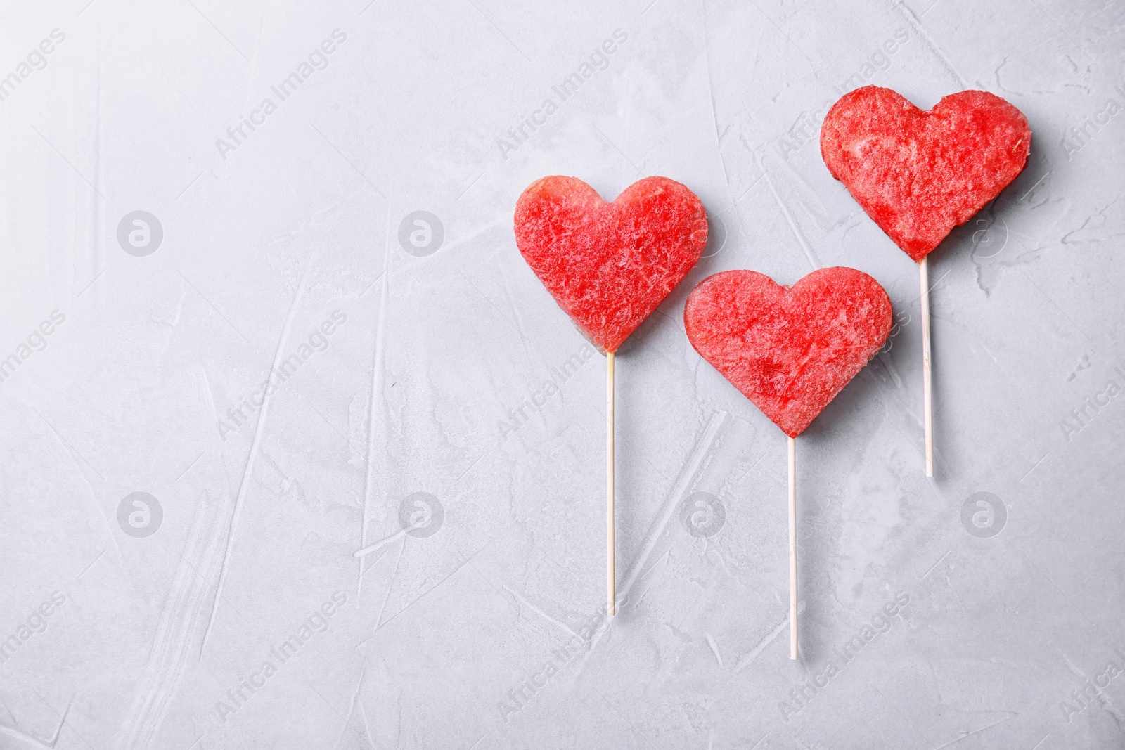 Photo of Flat lay composition with watermelon popsicles on grey background