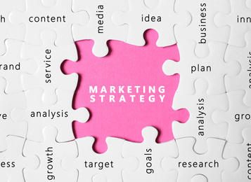 Business concept. White puzzle pieces with different phrases on pink background, top view 