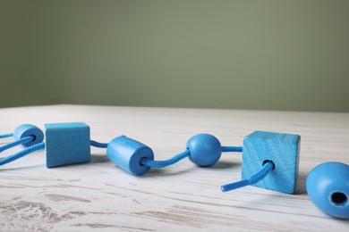 Photo of Wooden lacing toy on light table, closeup and space for text. Motor skills development