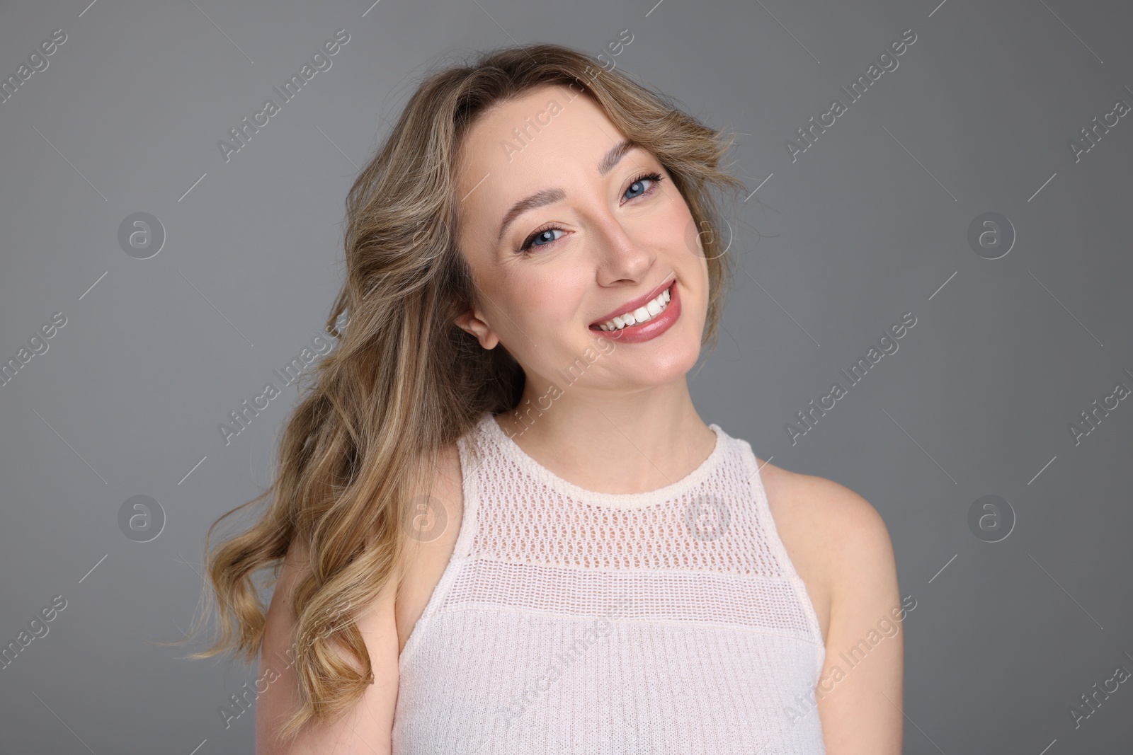 Photo of Portrait of smiling woman on grey background