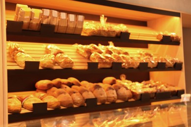 Blurred view of fresh pastries on counter in bakery store