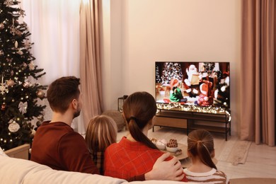 Photo of Family watching TV in cosy room. Christmas atmosphere