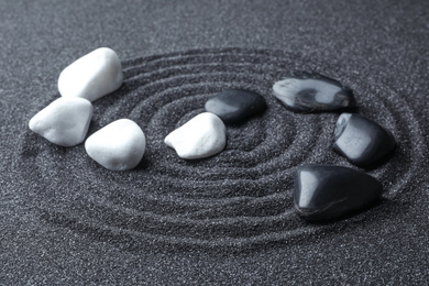 Photo of Stones on black sand with beautiful pattern. Zen and harmony