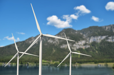 Image of Alternative energy source. Wind turbines near mountains