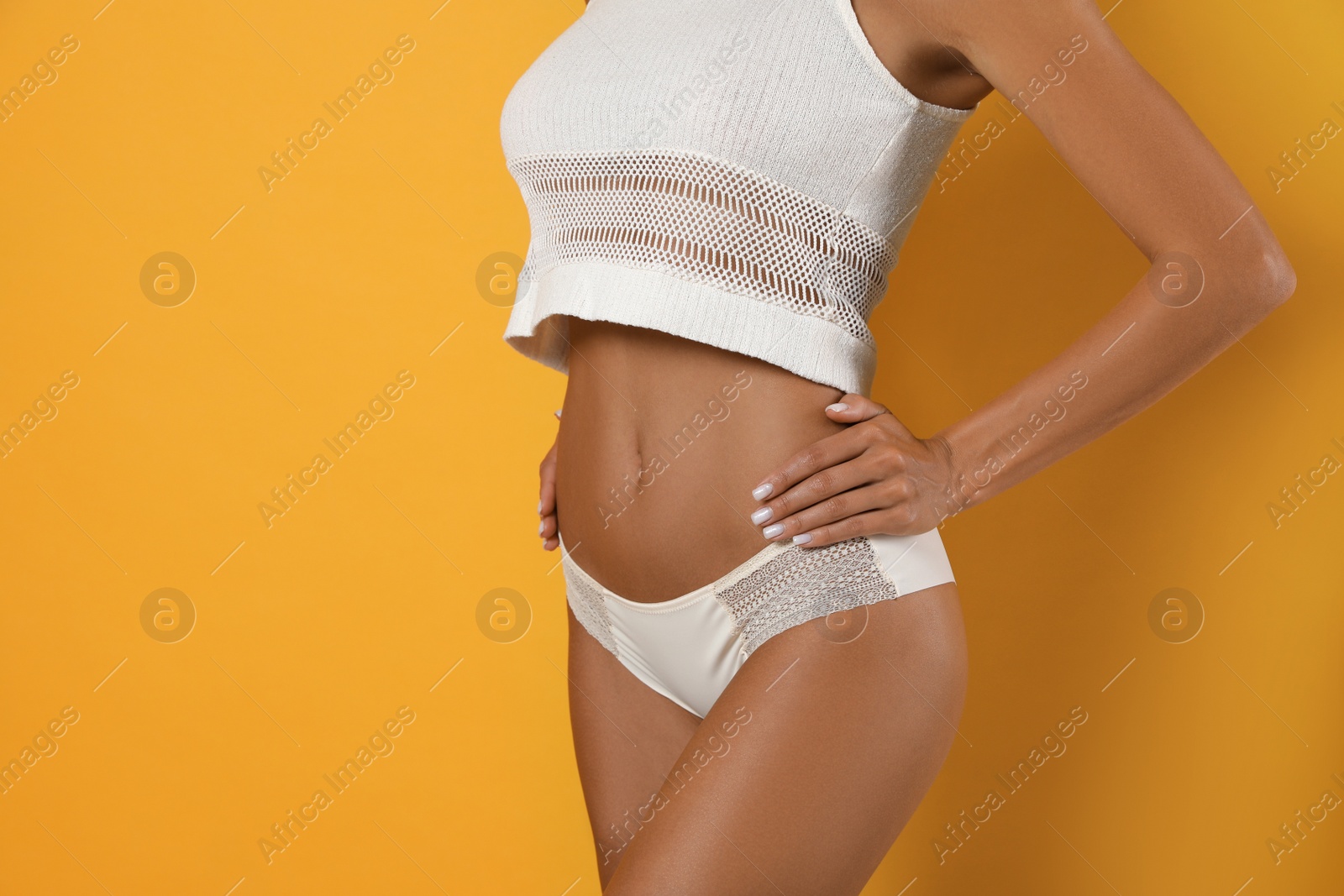 Photo of Woman in white sexy panties on yellow background, closeup