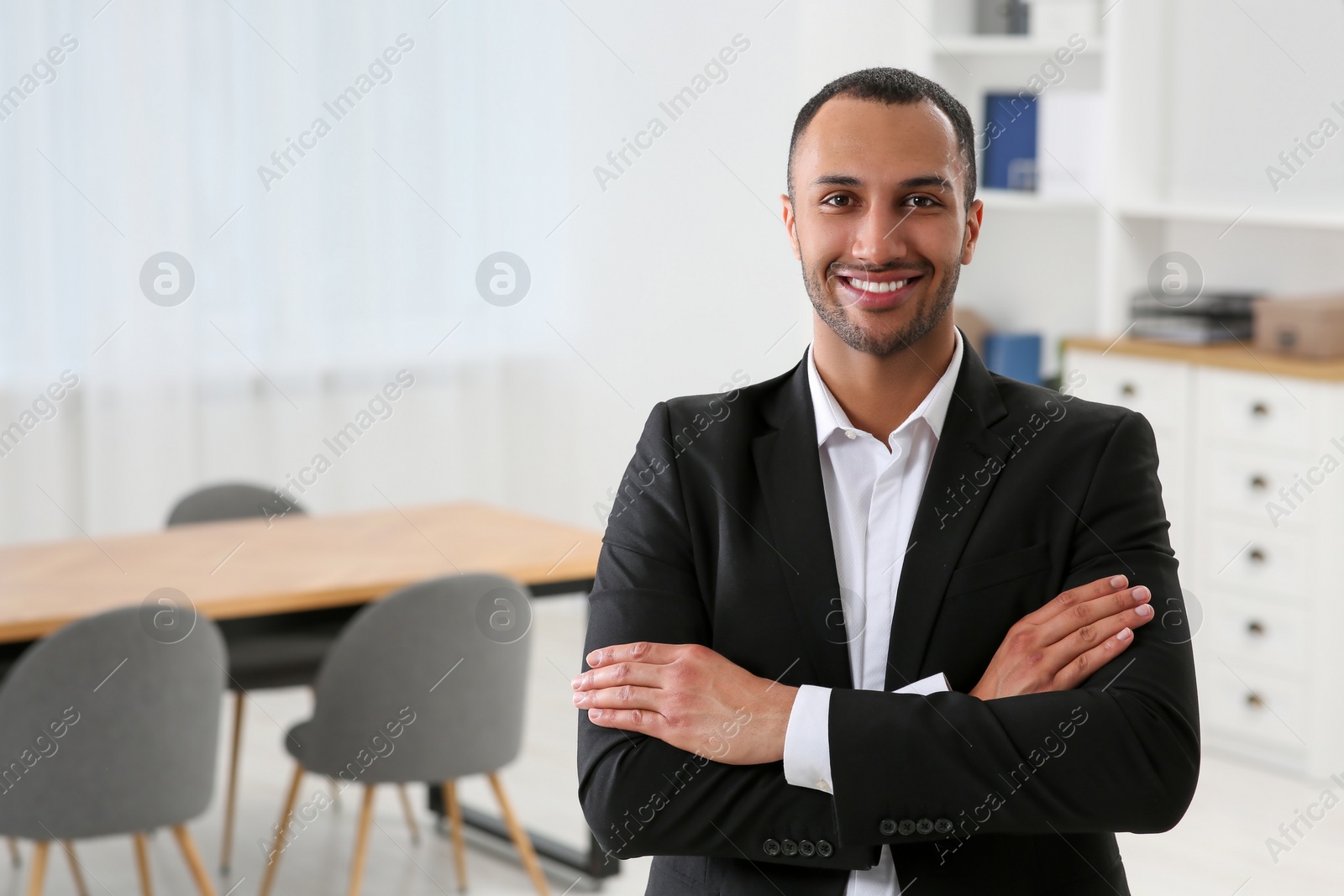 Photo of Smiling young businessman in office. Space for text