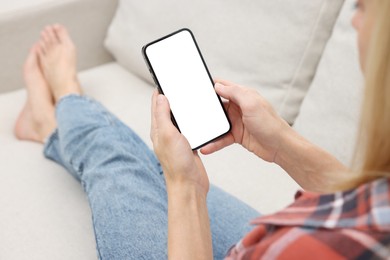 Photo of Woman using smartphone on couch at home, closeup. Space for text